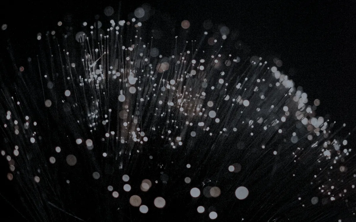 Macro di fibre ottiche illuminate su fondo scuro